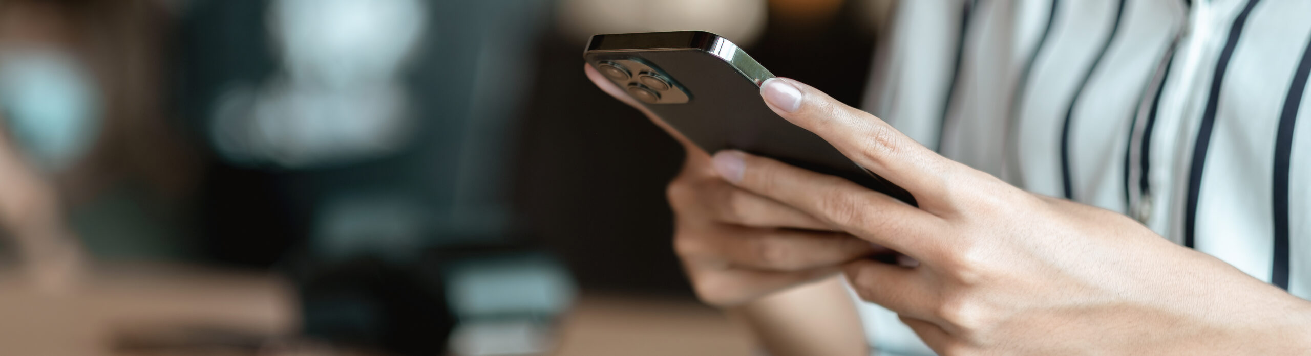 Close up hand of woman using smartphone at coffee shop cafe